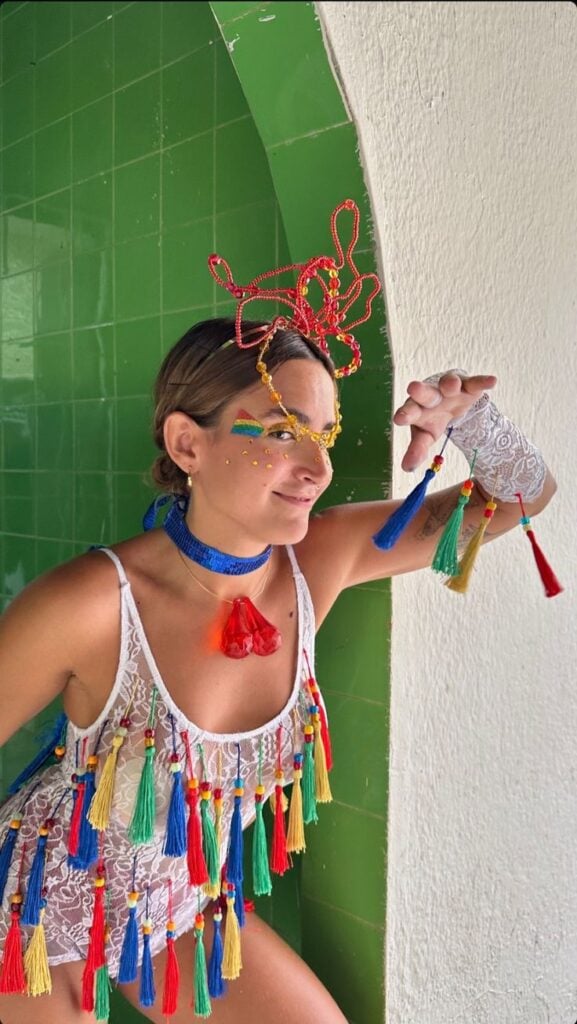 Mulher de pele clara, com body de renda branco com aplicações