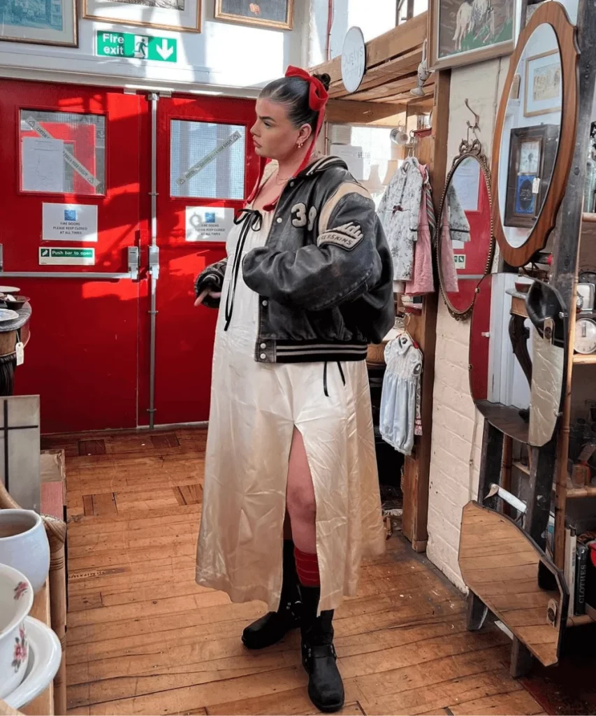 Mulher gorda em uma loja com um vestido, jaqueta de couro e biker boots