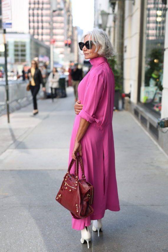 Mulher de 60 anos, cabelo curto e vestido rosa