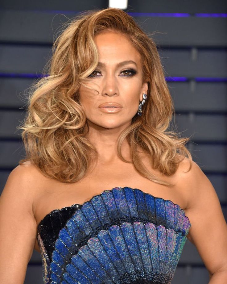 Jennifer Lopez com vestido azul e cabelo loiro mel