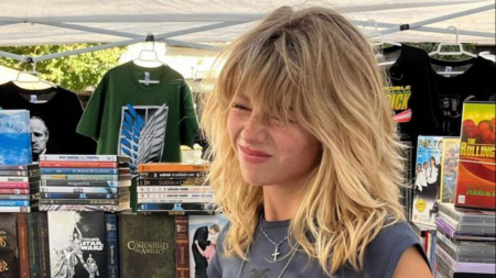 Mulher com o cabelo médio repicado em uma loja de livros