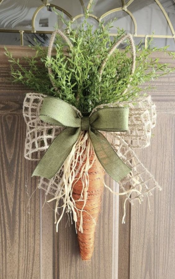 Guirlanda de Páscoa de cenoura com galhos verdes e laço verde e bege