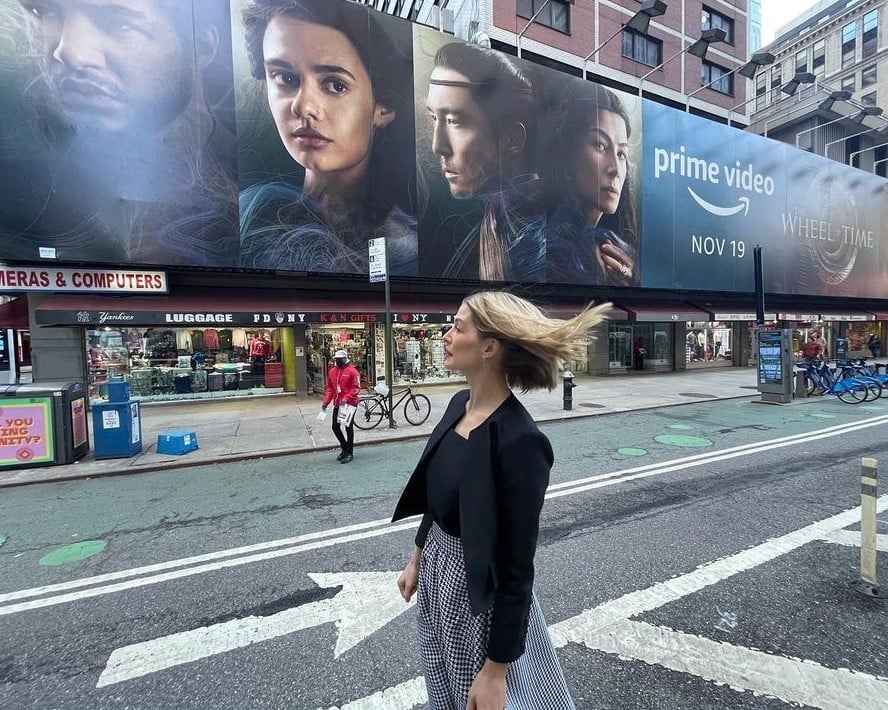 Atriz Rosamund Pike no meio da rua com cabelo curto loiro