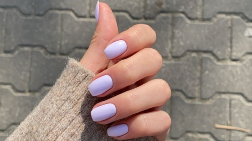 Mão branca com esmalte lilás