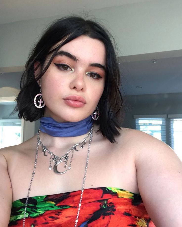 Atriz Barbie Ferreira com cabelo curto preto e acessórios prata