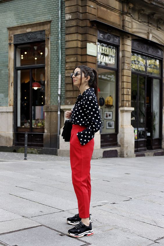 mulher usando camisa de bolinhas e calça vermelha 