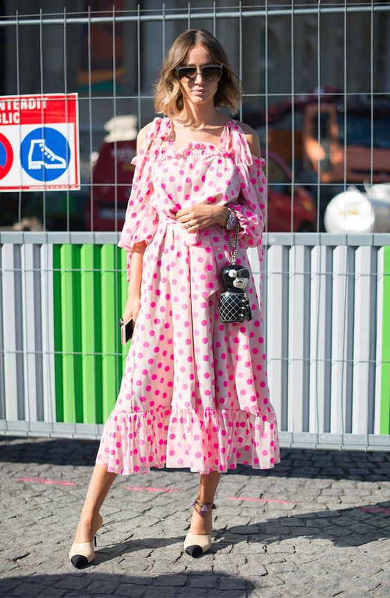 mulher usando vestido rosa com estampa de poá
