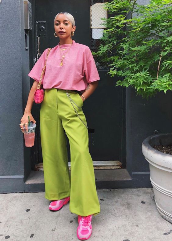 Mulher vestindo blusa rosa e calça verde