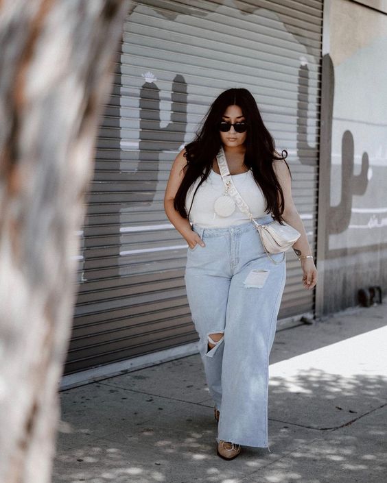 mulher na rua usando calça jeans em modelo plus size