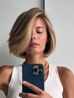 Mulher branca com cabelo loiro, curto e com franja longa