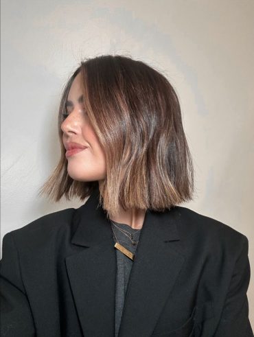 Mulher com cabelo liso e curto, no estilo blunt bob.