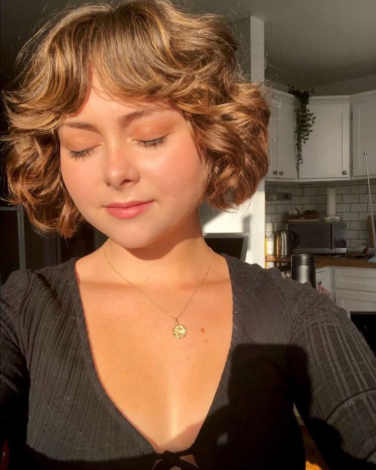 Mulher branca e jovem com cabelo curto no estilo bob com franja usando maquiagem marrom e laranja