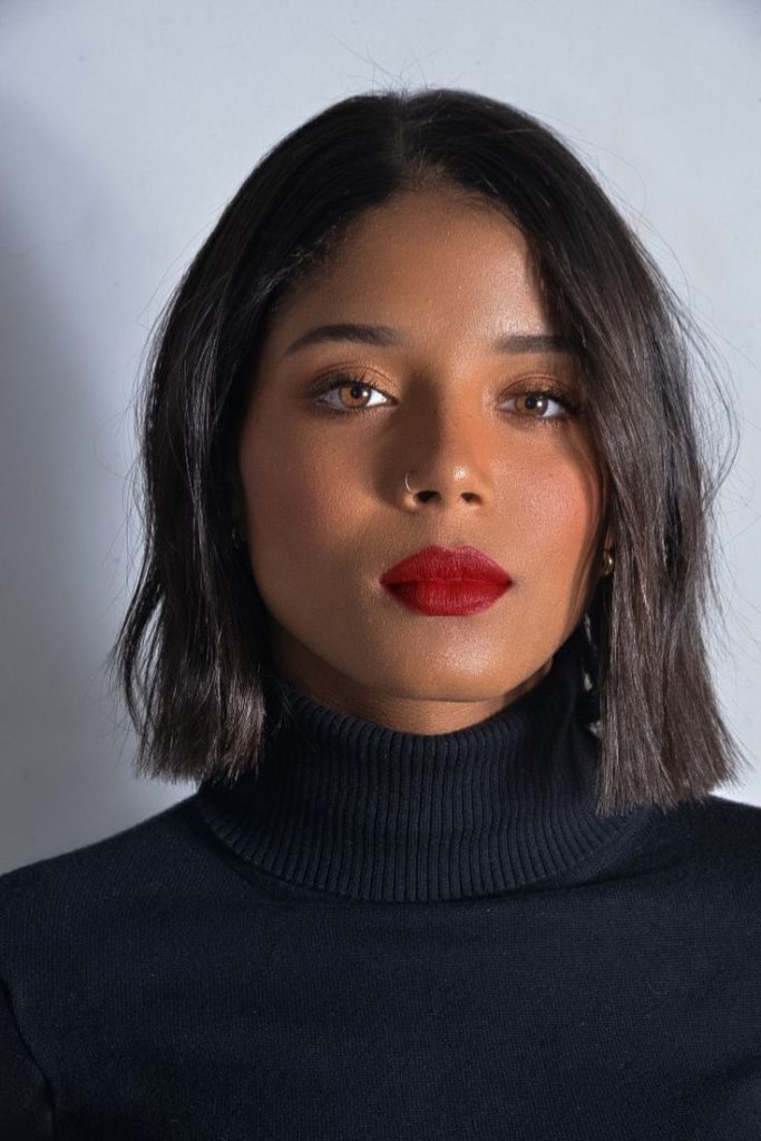 Mulher com cabelo liso e curto, no estilo blunt bob.