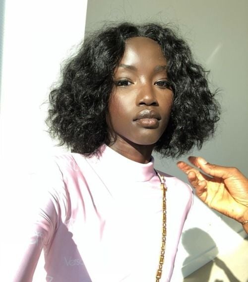 Mulher negra e jovem com cabelo curto no estilo french bob