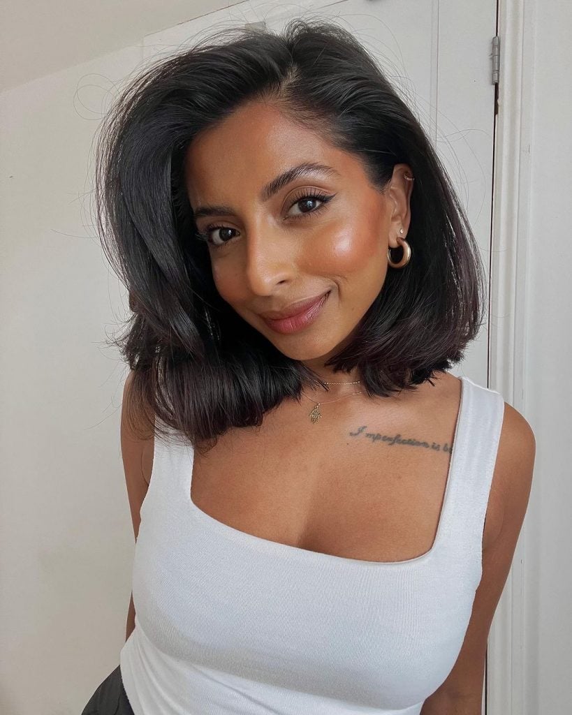 Mulher indiana com regata branca e cabelo preto estilo dad bob