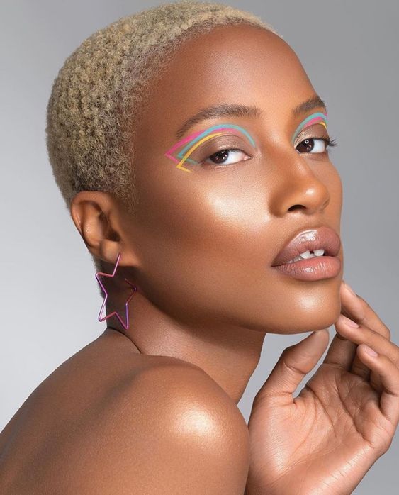Mulher negra com pixie cut e delineado gráfico colorido