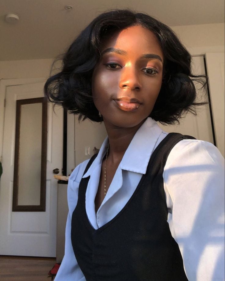 Mulher negra e jovem com cabelo curto no estilo french bob