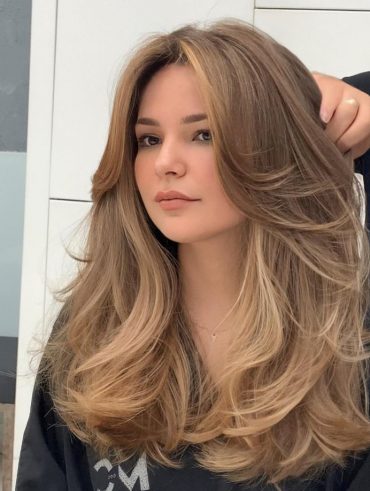 Mulher jovem com cabelo liso, com mechas, longo e franja, com corte butterfly cut