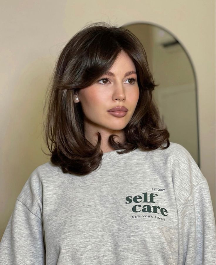 Mulher com moletom cinza e cabelo curto com franja 