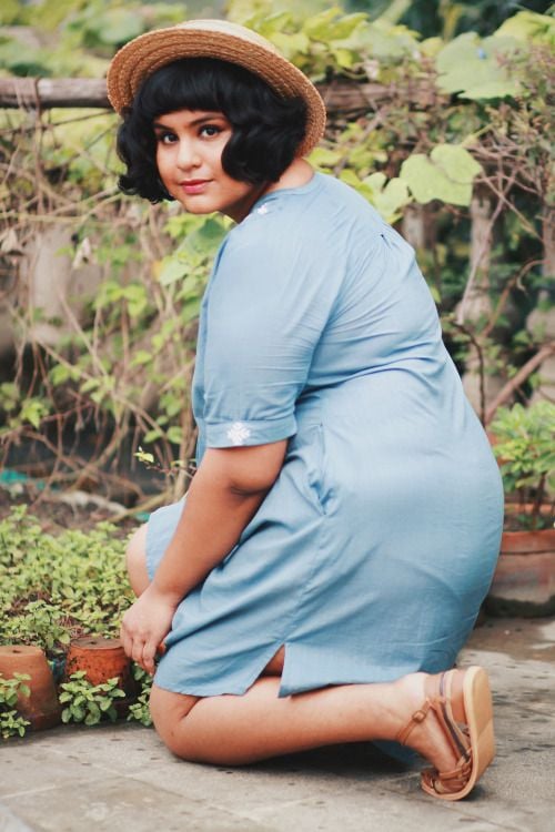Mulher branca e jovem com cabelo curto no estilo french bob de chapéu