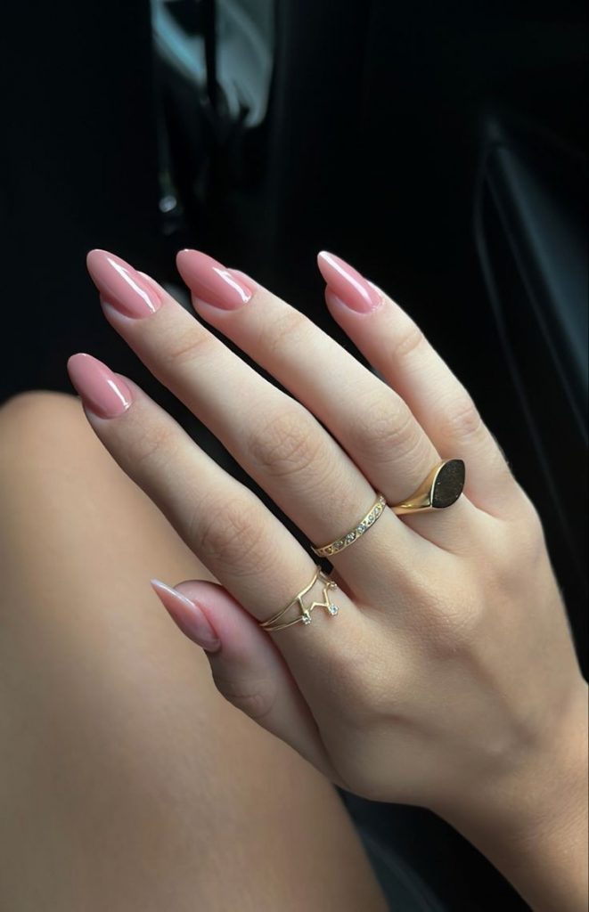 Mão branca com anéis e unha rosa claro