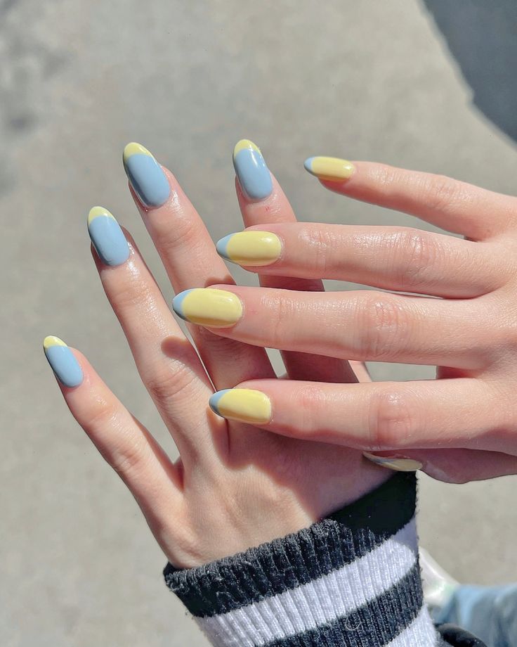 Mãos brancas com manga listrada, e unhas azul com francesinha amarela e o inverno