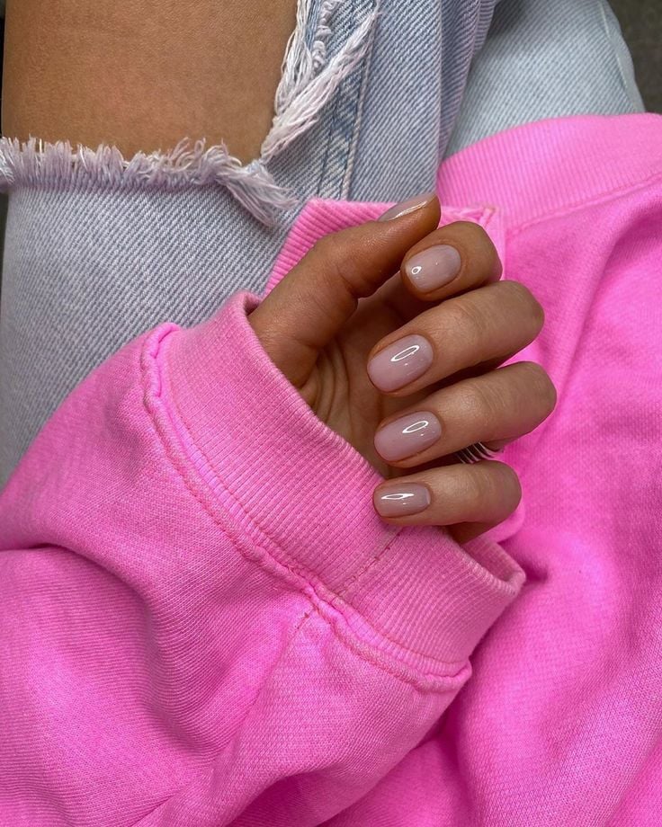 Mão negra com manga rosae unha curta nude