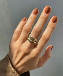 Mão com anel e unha curta nude