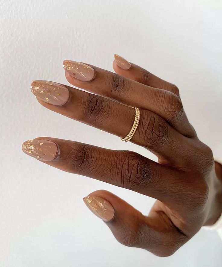 Mão negra com anel e unha curta amendoada transparente e decorada