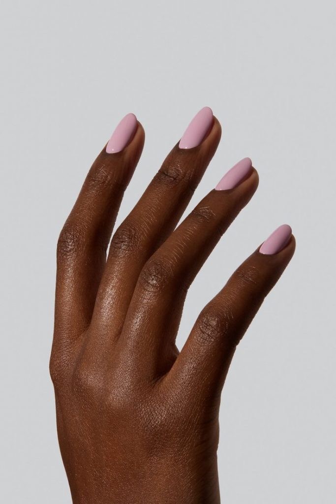 Mão negra com unha curta rosa