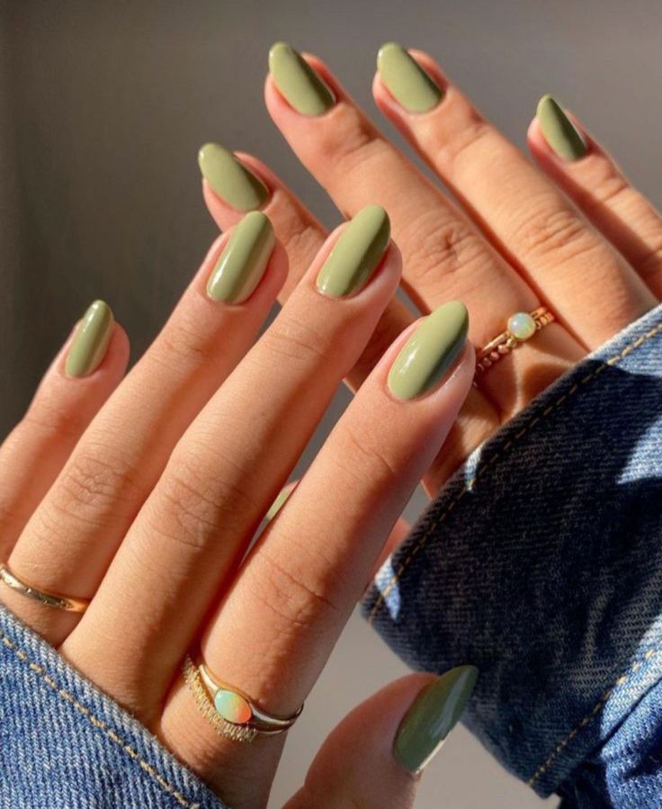 Mãos branca com manga jeans, anéis e unha verde pistache