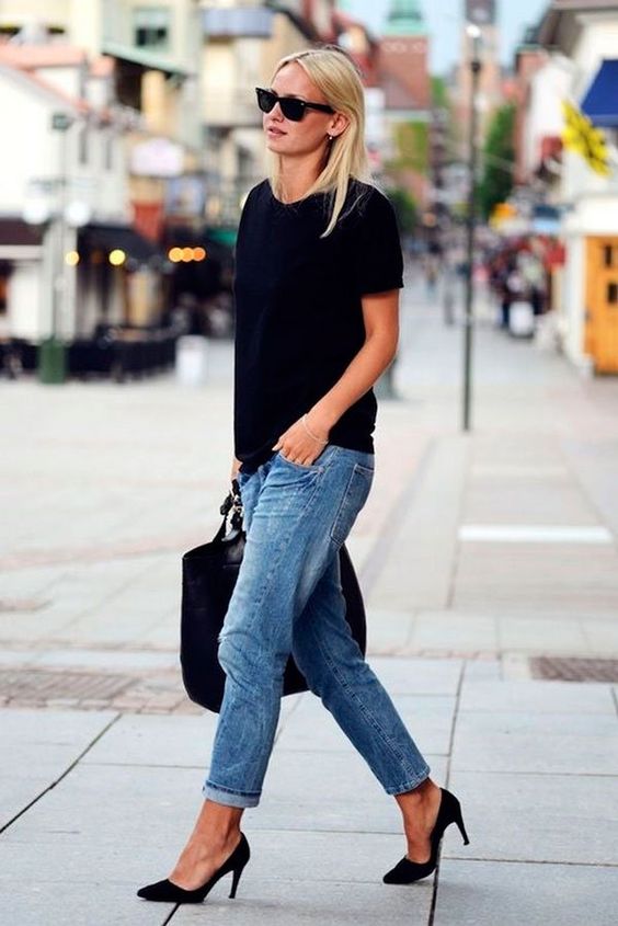 mulher andando com blusa preta e calça jeans clara