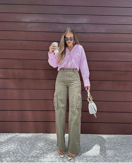 Mulher usando camisa rosa, calça cargo verde e salto alto