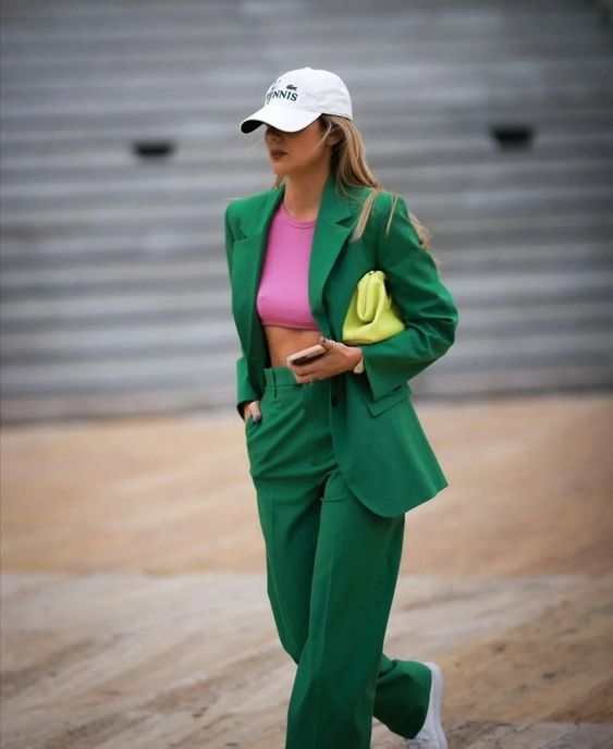 Mulher vestindo blazer e calça verde com boné branco