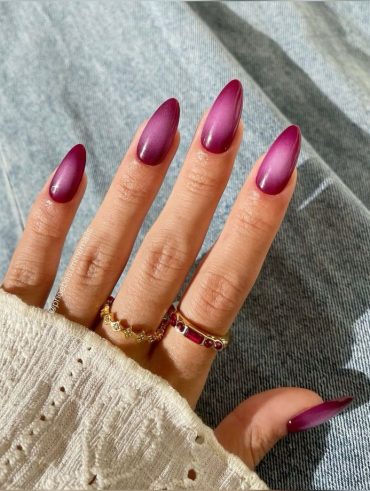 Mão branca com anéis e unha aura rosa
