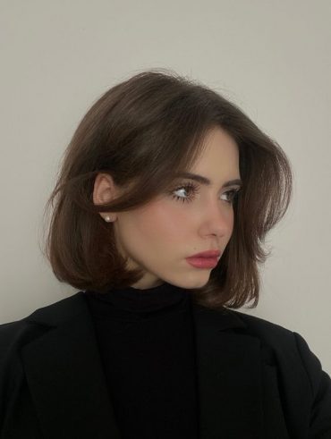 Mulher branca com cabelo curto chanel romântico castanho com franja borboleta