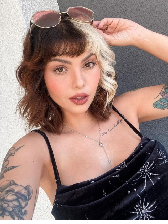 Mulher com vestido preto e cabelo de duas cores com corte repicado
