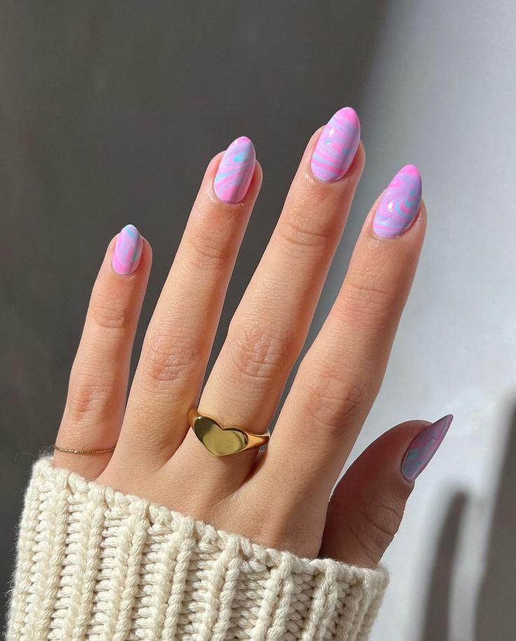 Mão branca com manga off-white, anel dourado e unha estilo doce