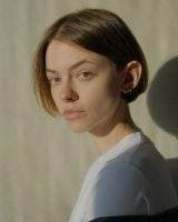 Mulher branca com cabelo chanel, curto, loiro claro e liso