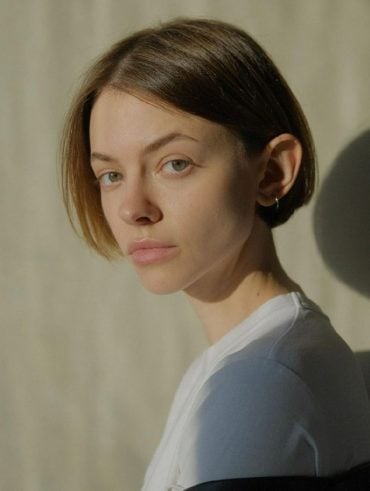 Mulher branca com cabelo chanel, curto, loiro claro e liso