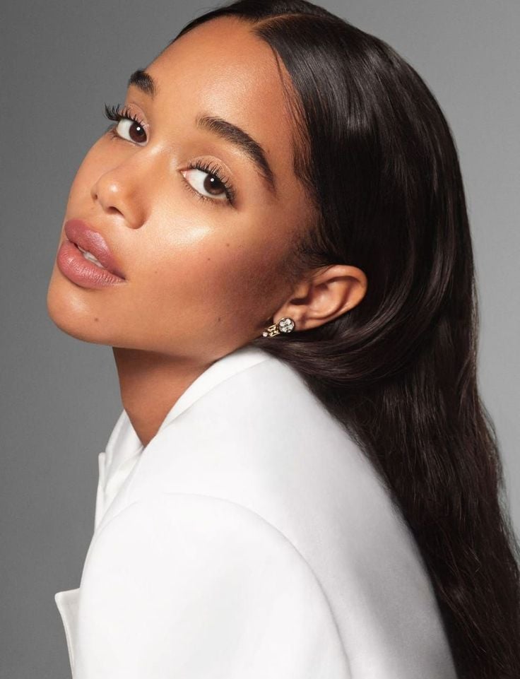 Mulher negra com blusa branca, cabelo liso e maquiagem elegante