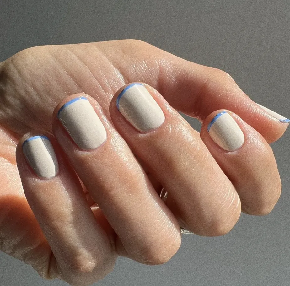 Mão branca curvada com microfrancesinha azul
