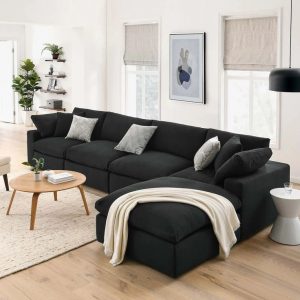 Sala com sofá em L preto e mesa de centro em madeira