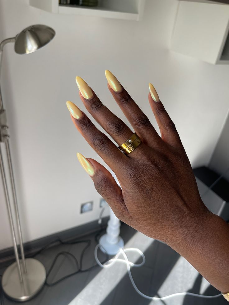Mão negra com anel e unha amarelo manteiga