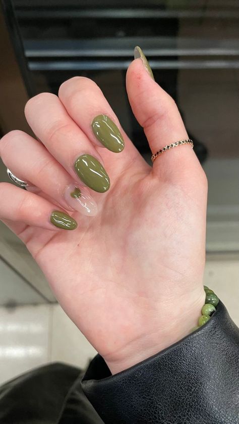 Mão branca curvada com anel e unha amendoada verde oliva