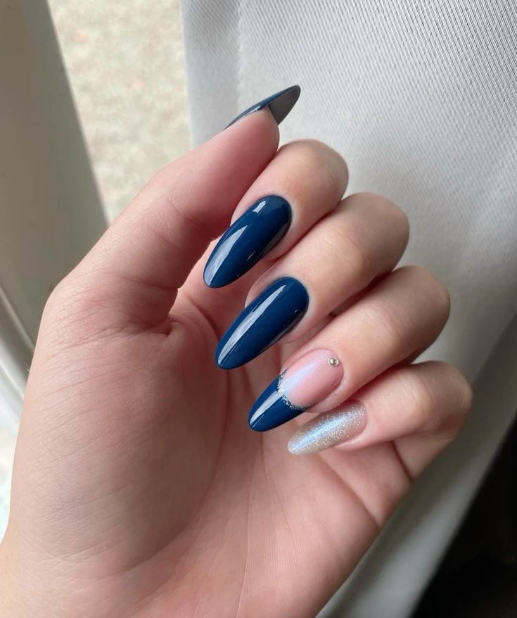 Mão branca curvada com unha azul petróleo decorada com francesinha, brilho e strass