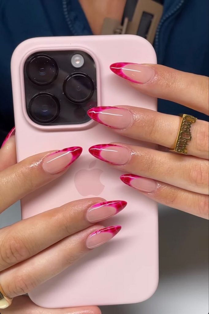 Mãos brancas apoiadas na capinha com unha rosa e francesinha pink com estampa de tartaruga