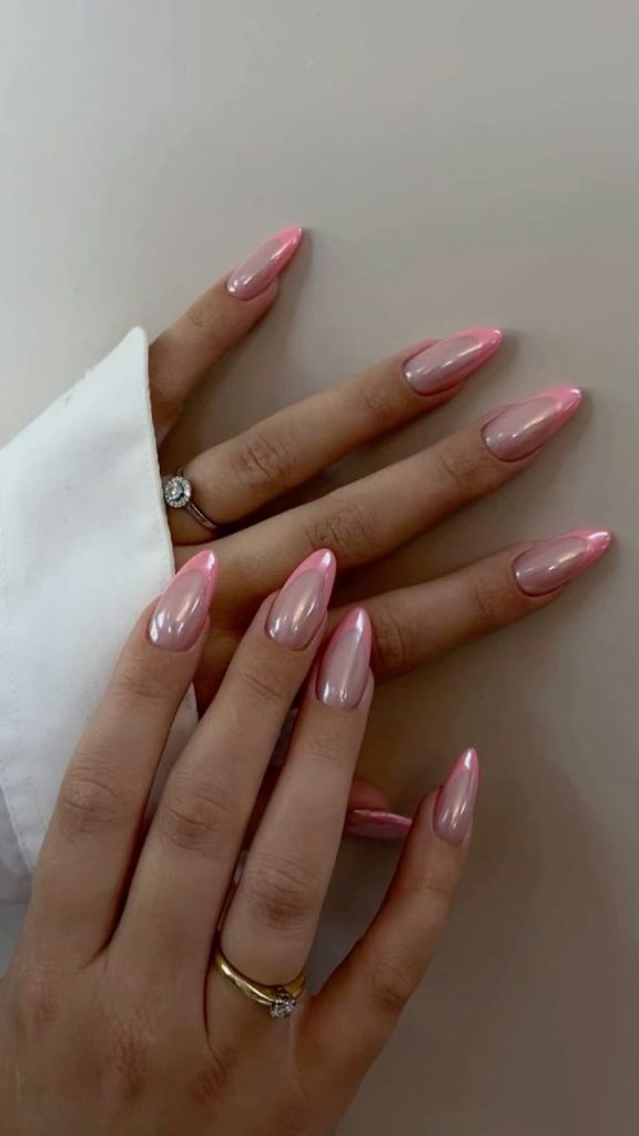 Mãos brancas sobrepostas com anel e unha com francesinha rosa perolada