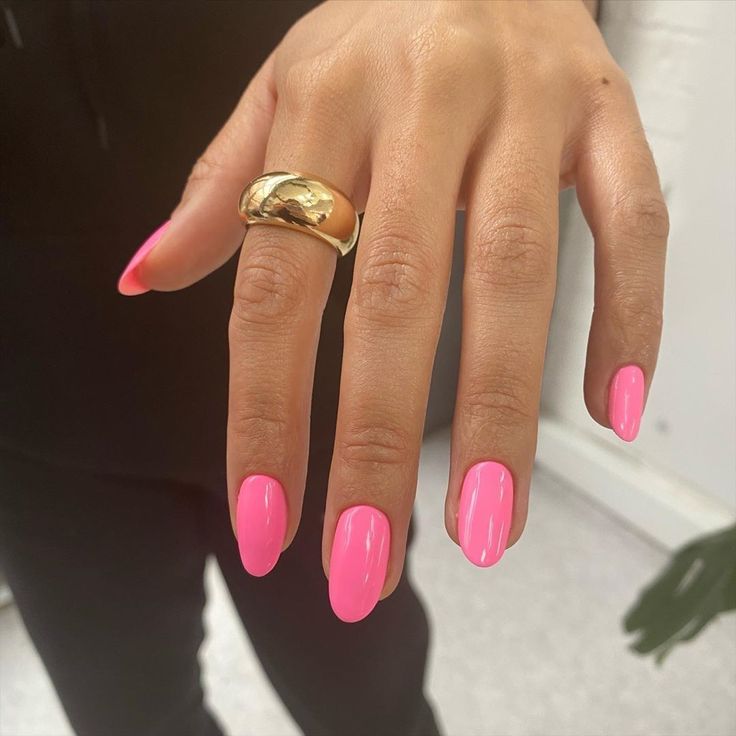 Mão branca com anel e unha rosa pink