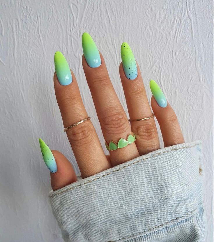 Mão branca com anéis e unha degradê verde e azul